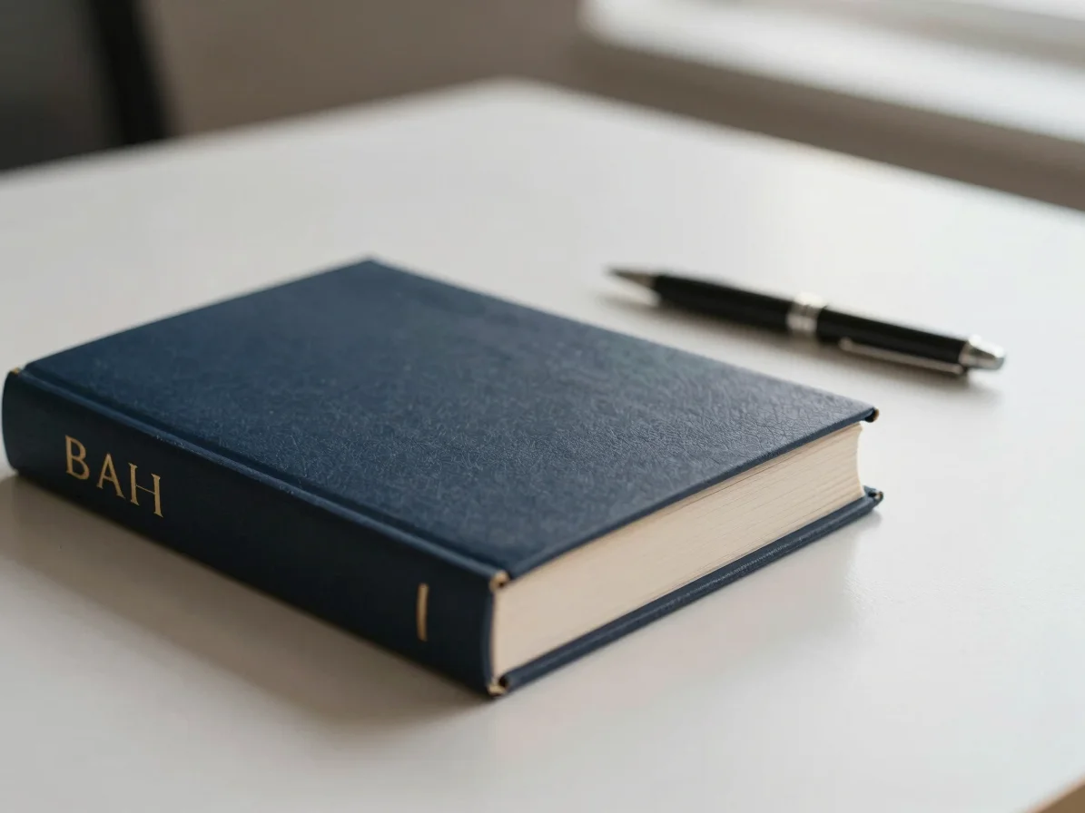 Close-up of legal books and a pen on a clean, light-colored desk,